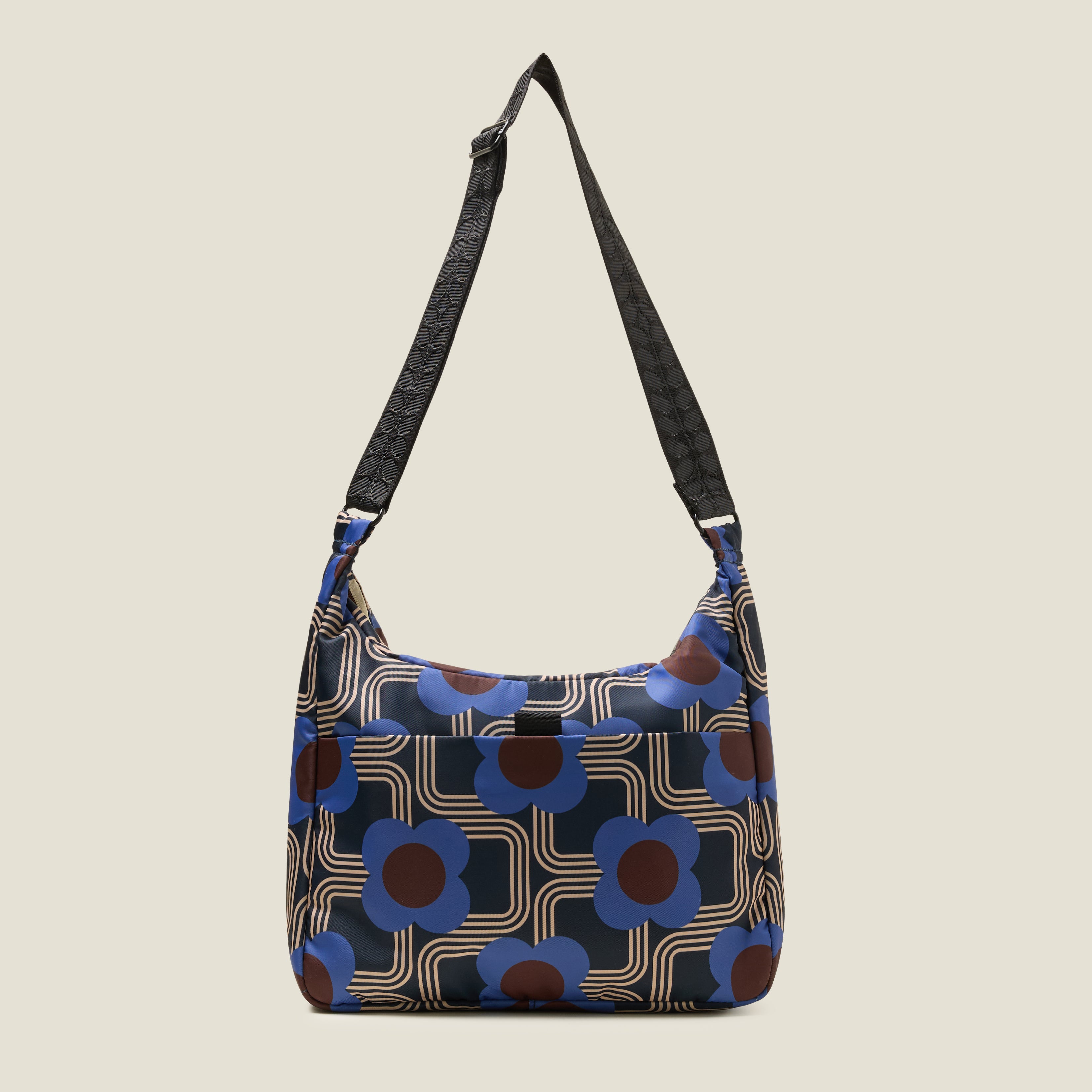Back view of crossbody bag in an electric blue floral pattern. Adjustable shoulder strap and back slip pocket with tab.