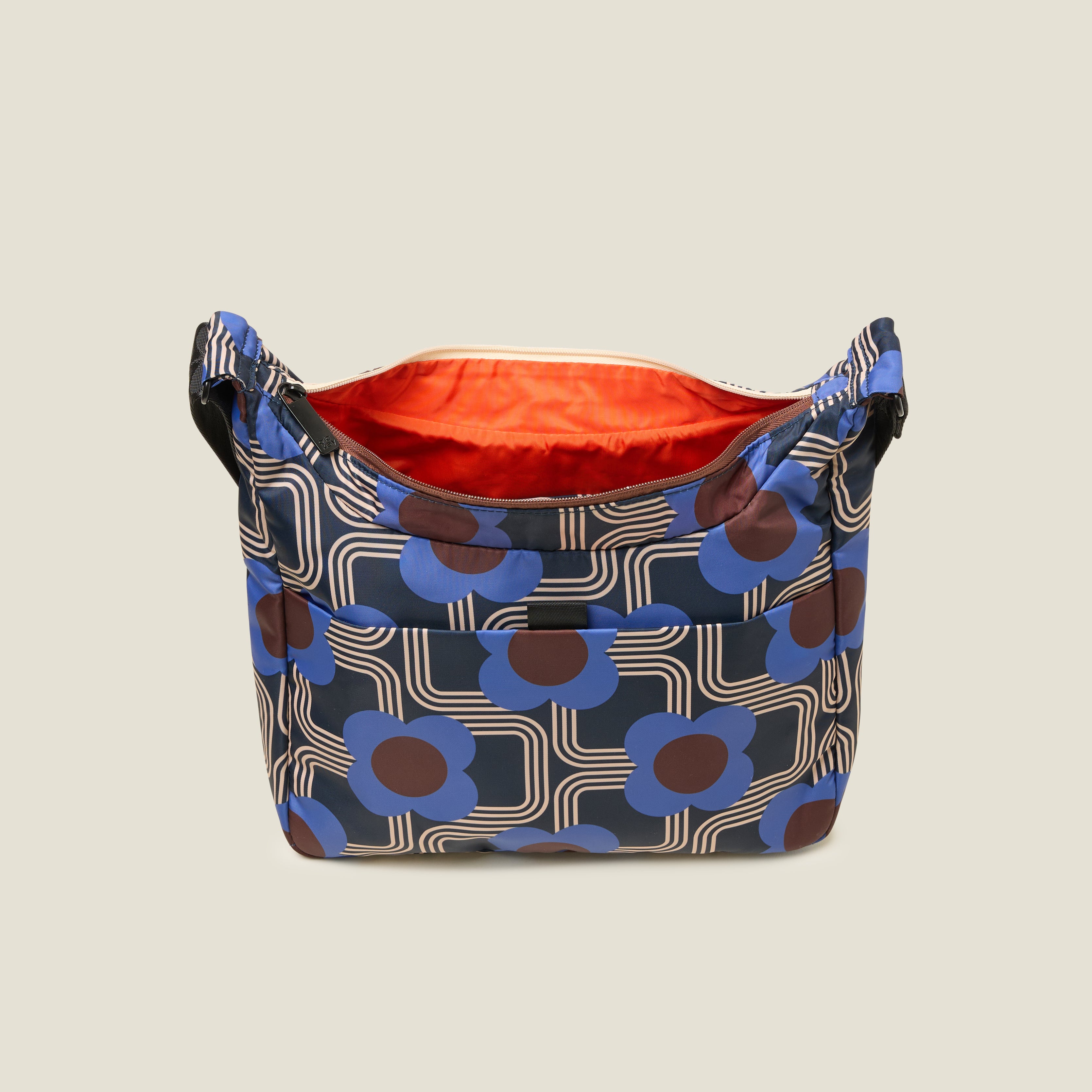 Top view of crossbody bag in an electric blue floral pattern with the zipper open to reveal the inside zip pocket and orange lining.