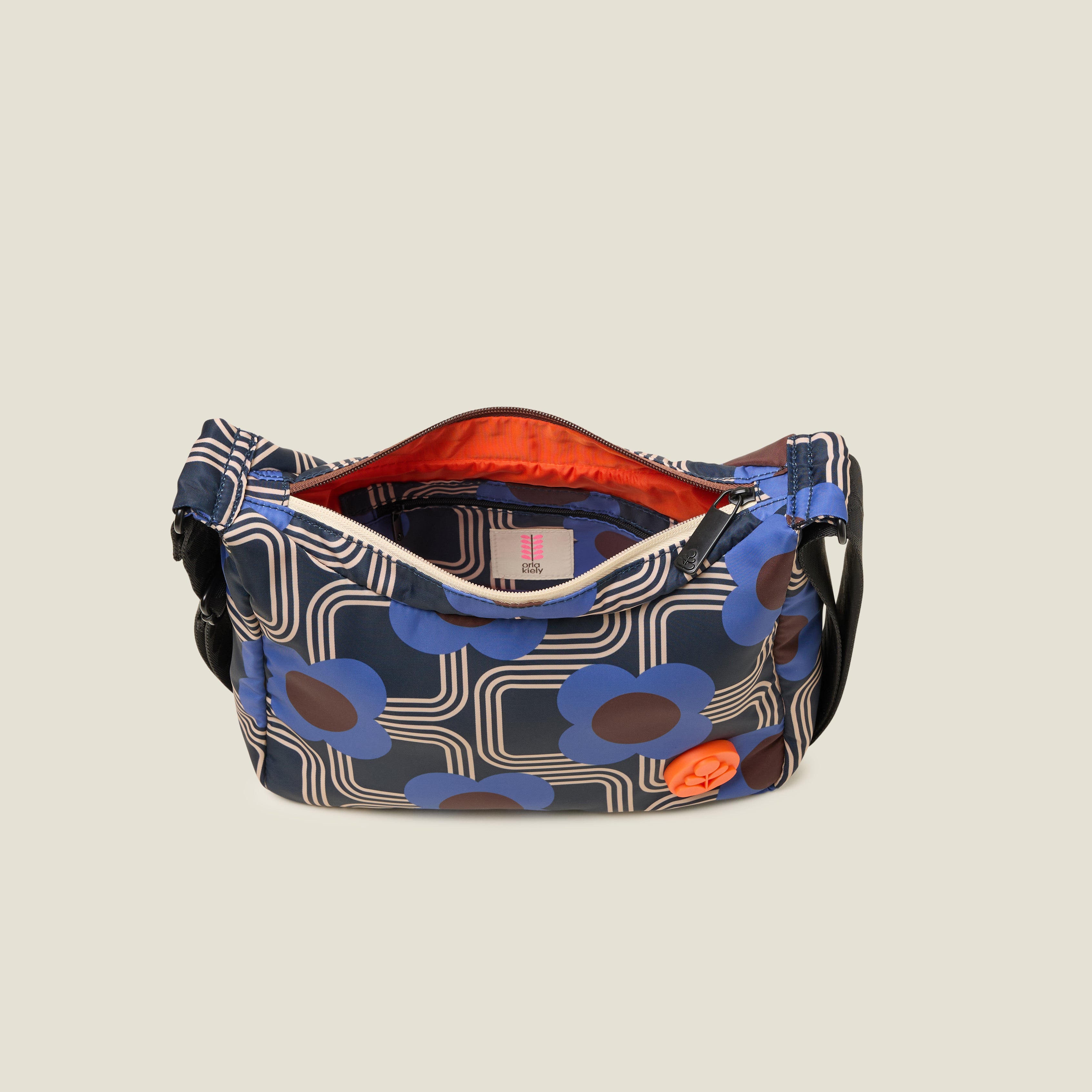The top view of the small crossbody hobo bag with the zipper open to reveal the orange lining, in our cobalt blue pattern with orange stem logo branding.