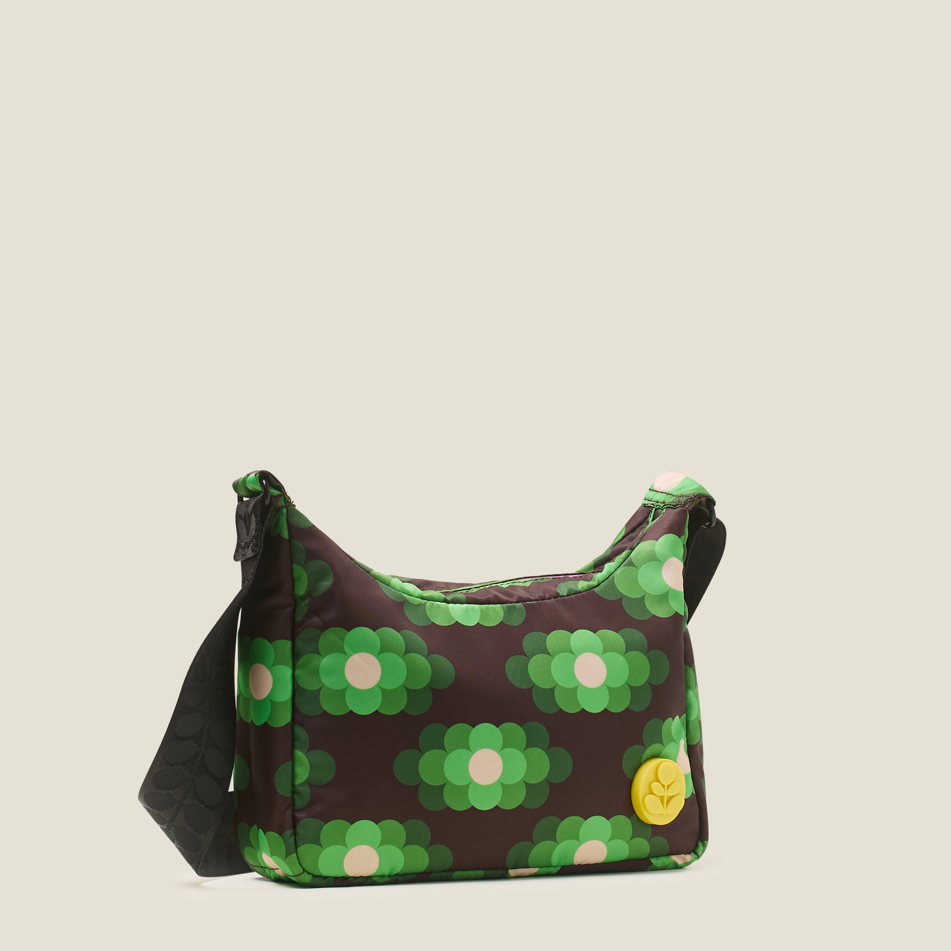 The side view of small hobo bag with neon green floral pattern, yellow stem logo branding and black adjustable strap.