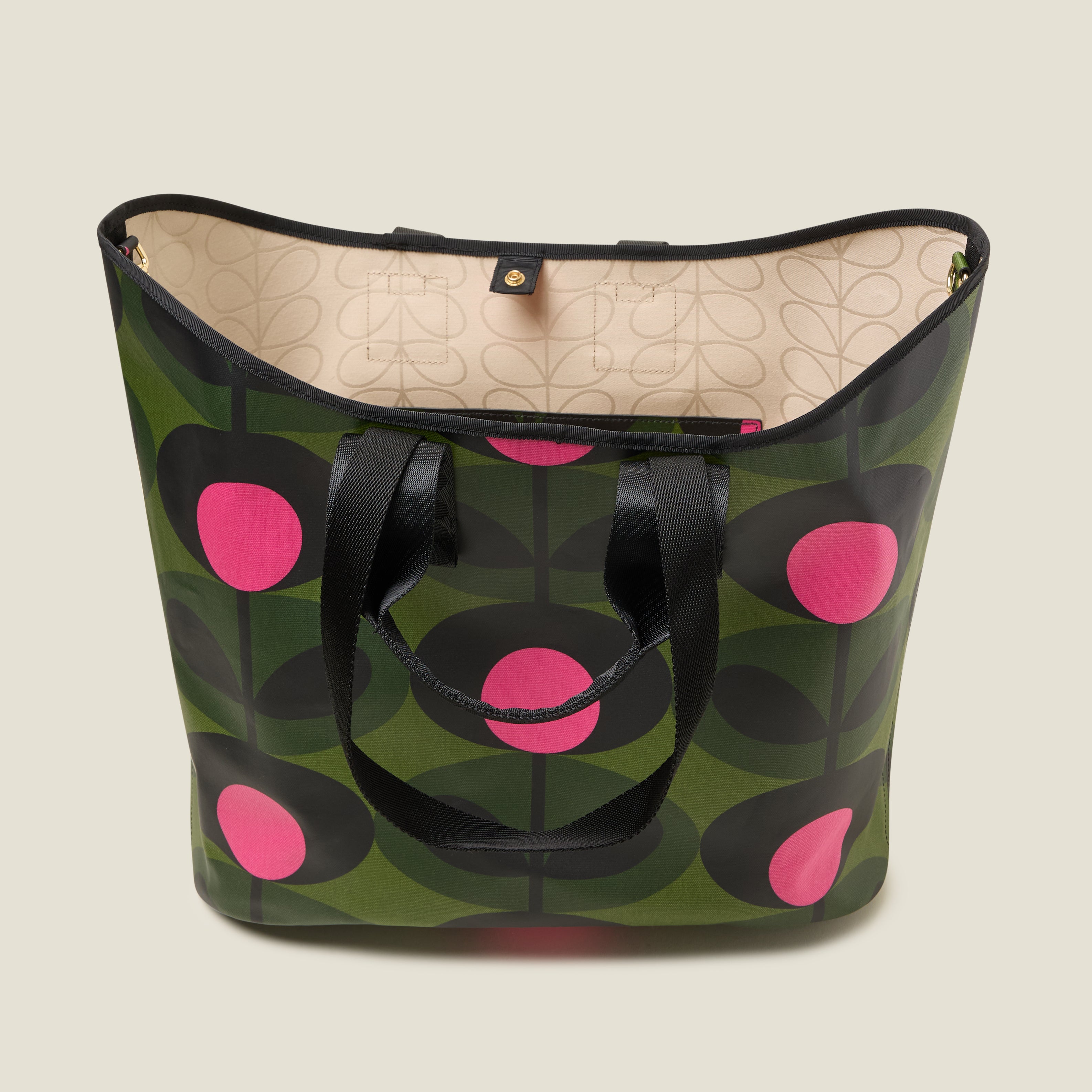 The top view of a large green tote bag with pink and black floral pattern with Orla Kiely webbing handles and shoulder strap. Inside features a zip pocket and snapper fastening.