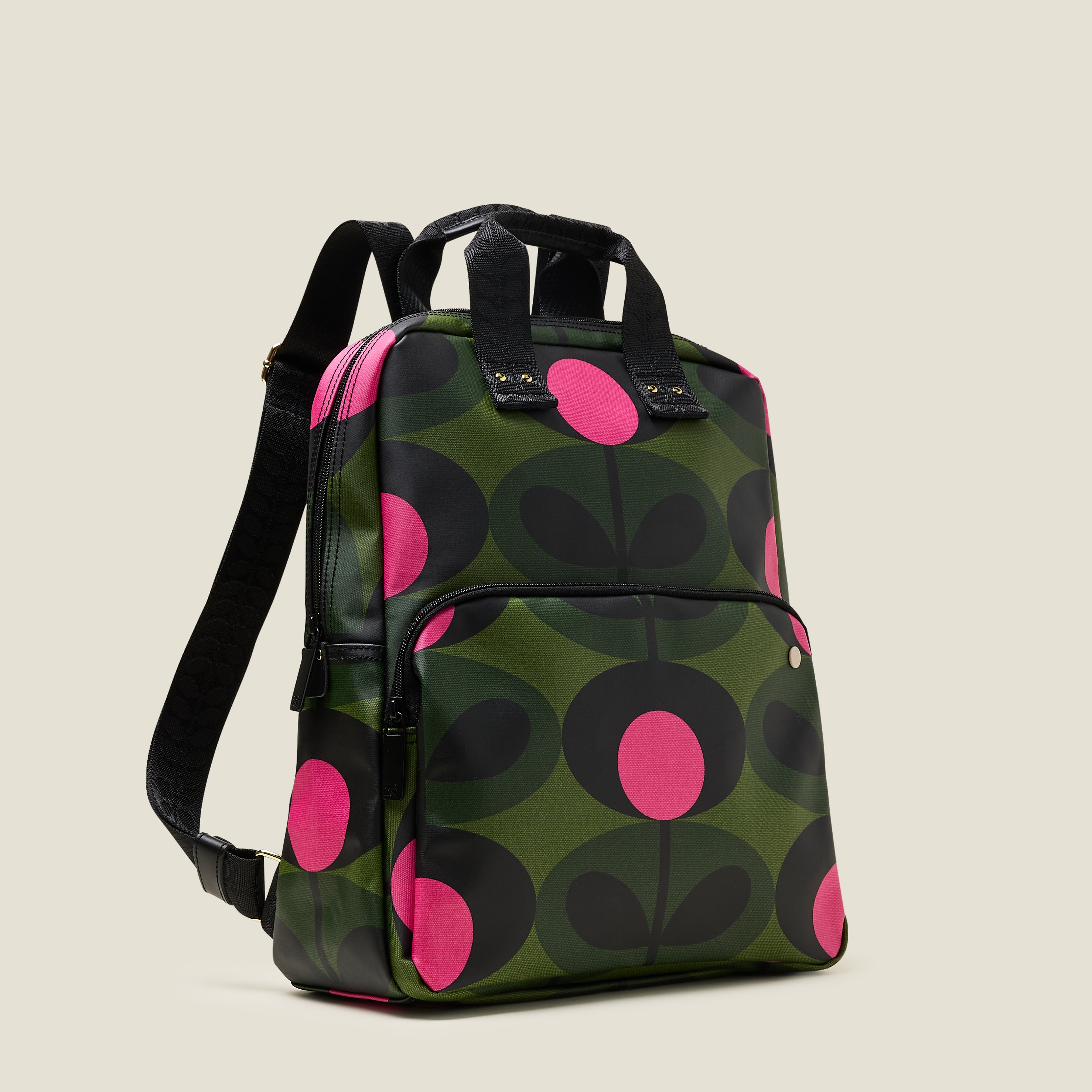 Side view of the Lotta Backpack in a green stem print with bright pink dots, featuring a zipped front pocket, branded grab handles and adjustable shoulder straps.