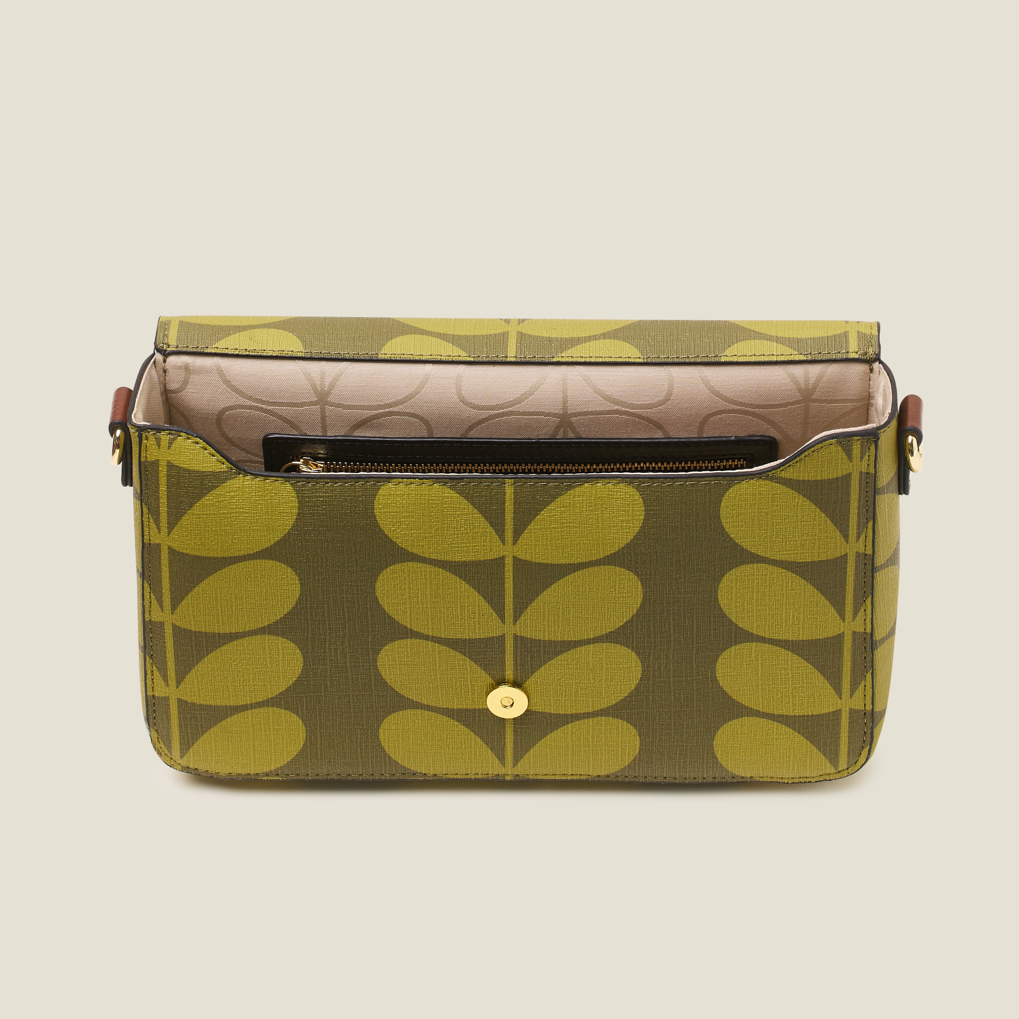 Top view of a women's handbag with green leaf pattern thats open to reveal a internal zip pocket and branded lining.