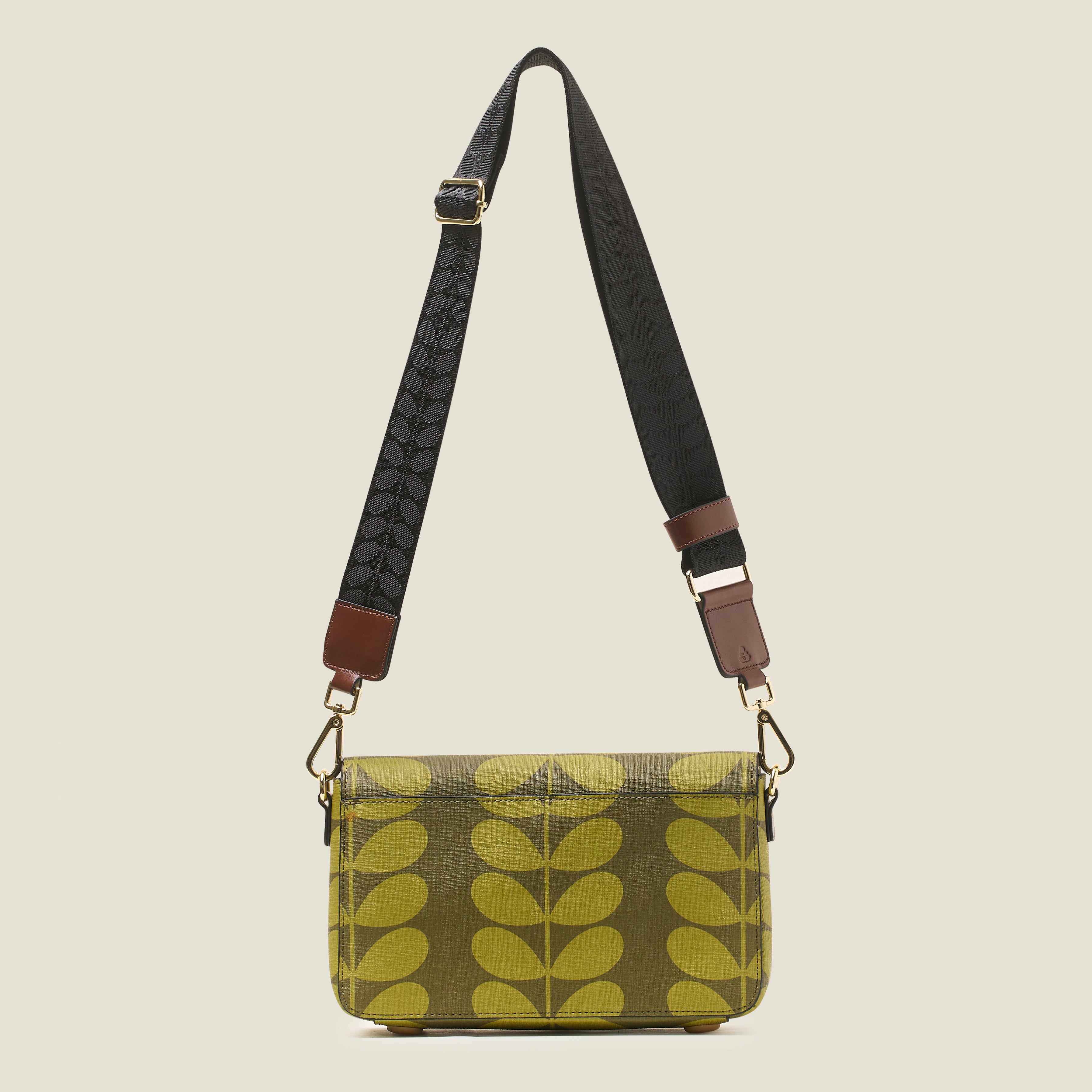 Back view of a women's handbag with green leaf pattern, featuring a detachable crossbody strap.