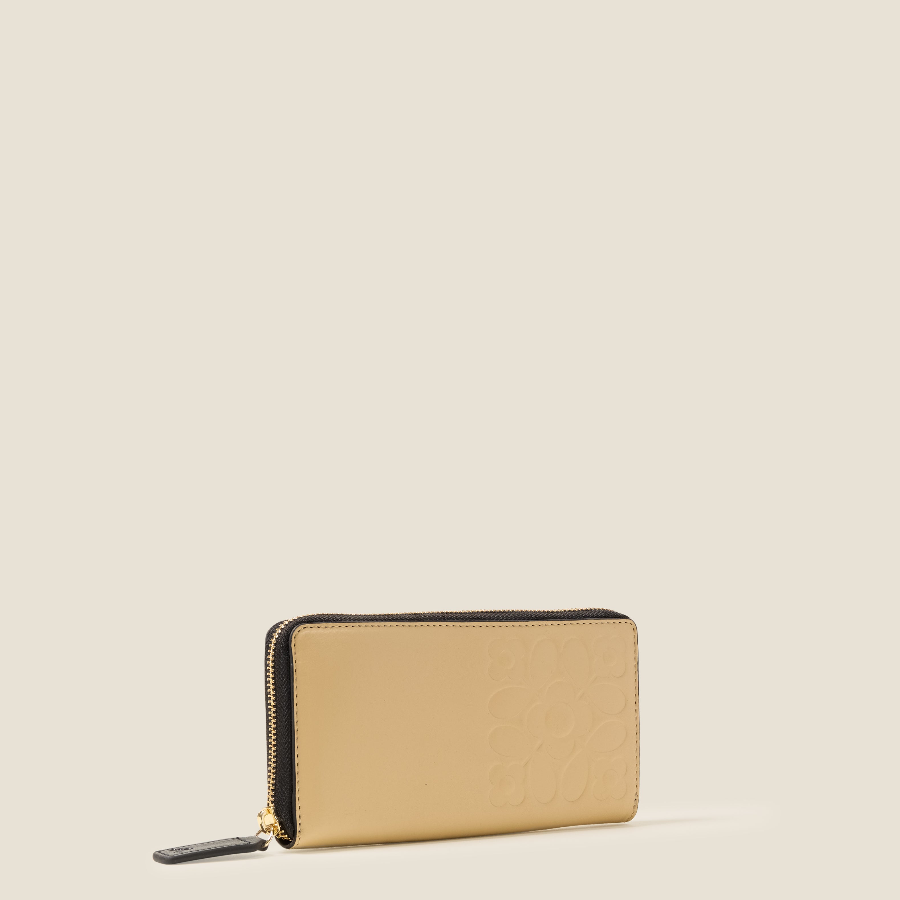 Side view of a cream leather wallet with black zipper, featuring an Orla Kiely embossed pattern.
