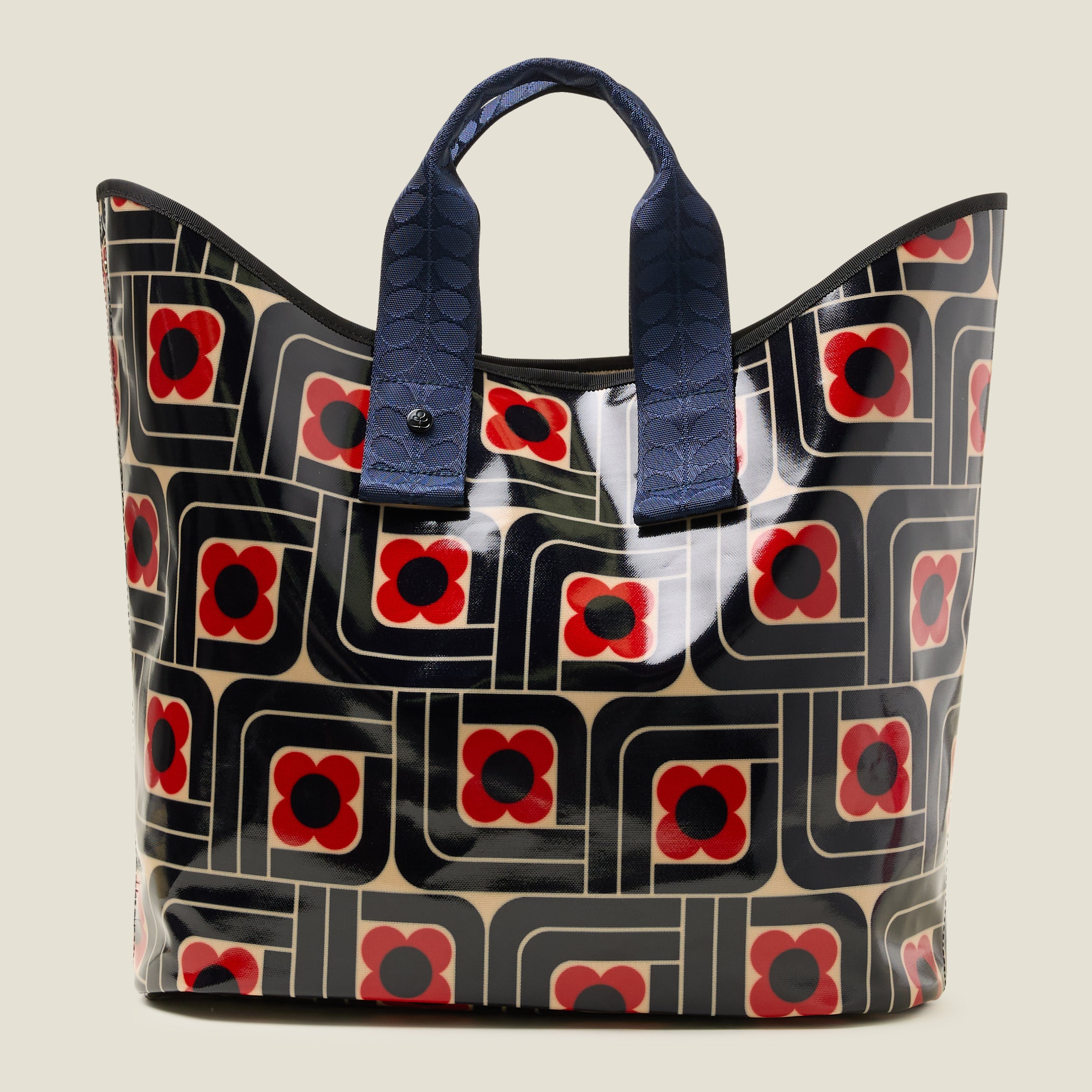 Front view of large patterned tote bag with red, navy and cream woodblock design, with navy grab handles.