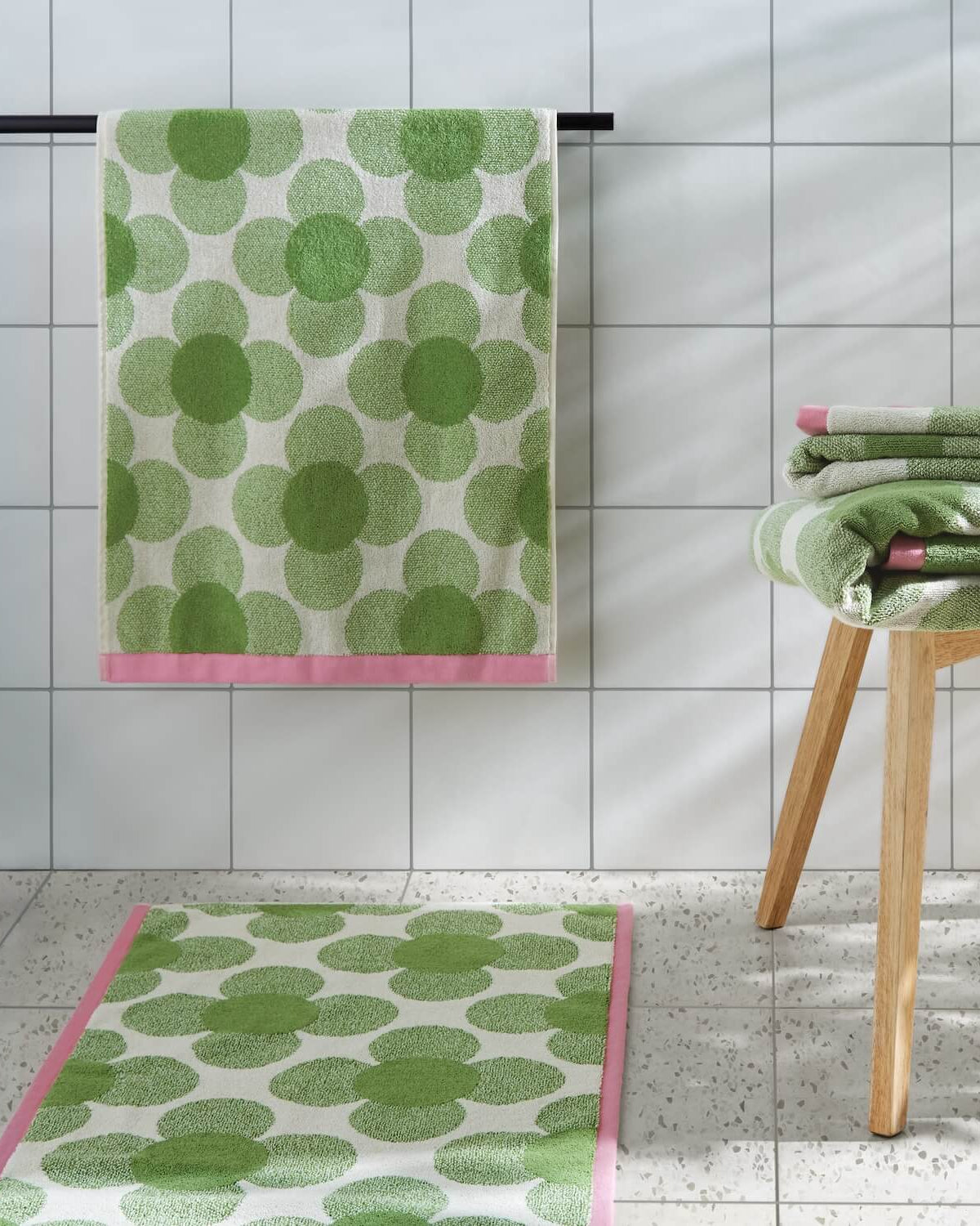 Lifestyle shot of the entire Orla Kiely retro flower clover green towel range
