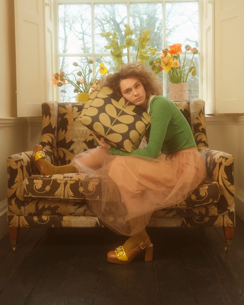 Model hugging a classic stem Orla Kiely bag 