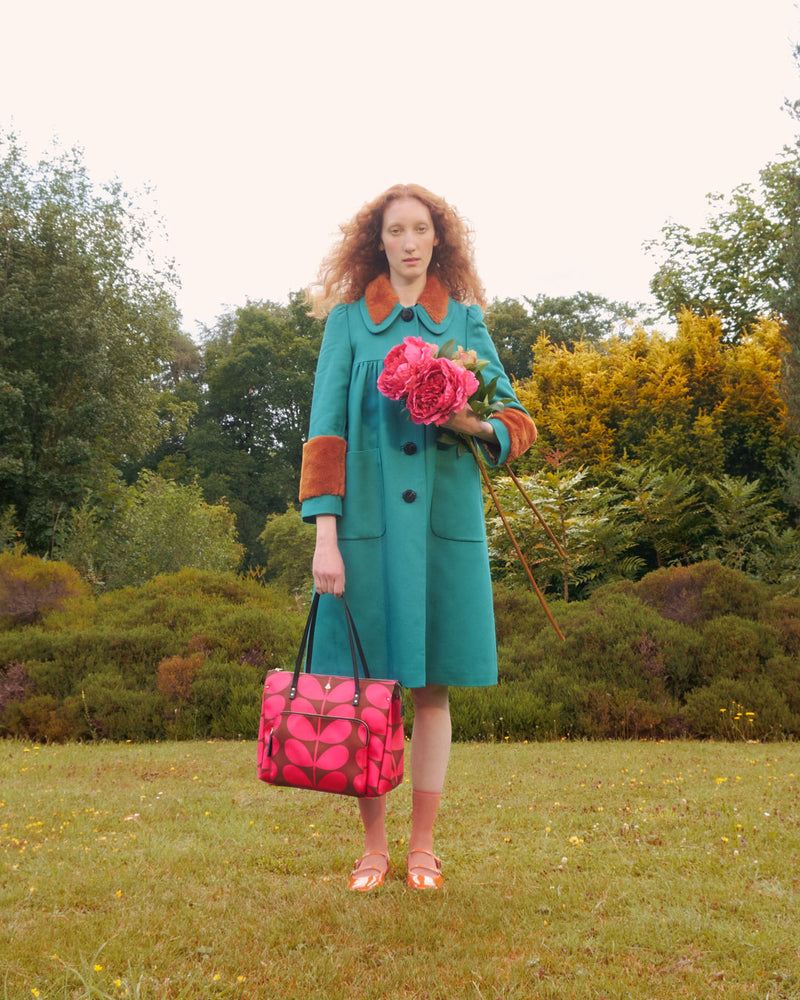 Women holding an Orla Kiely Watson Tote bag in a garden