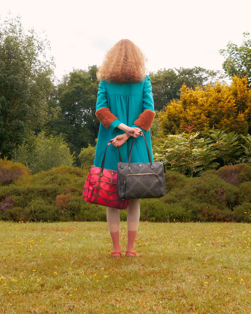 Women holding two Orla Kiely Watson Tote bags in a garden