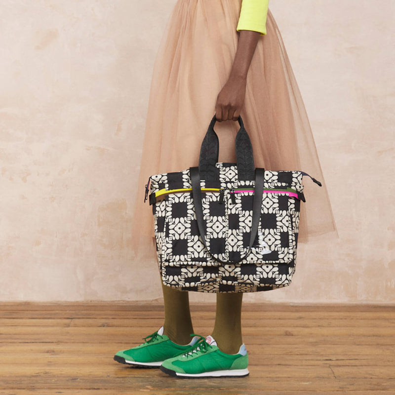 Model wearing the Axis Tote Bag in Lattice Flower Tile Onyx pattern by Orla Kiely