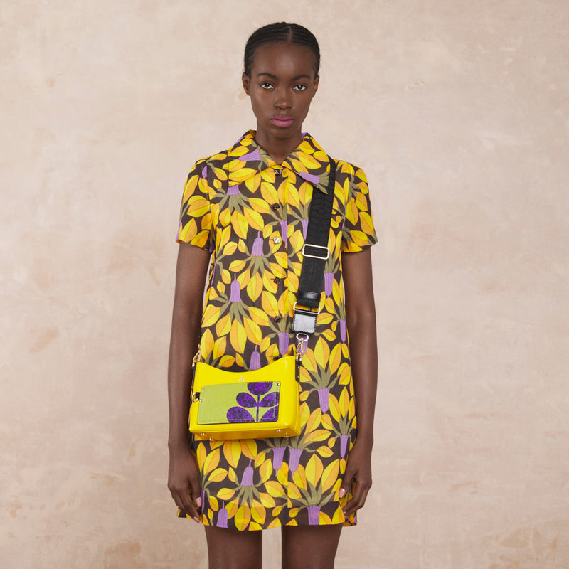 Model wearing the Carrymin Crossbody Bag in Daffodil Puzzle Flower Emblem pattern by Orla Kiely