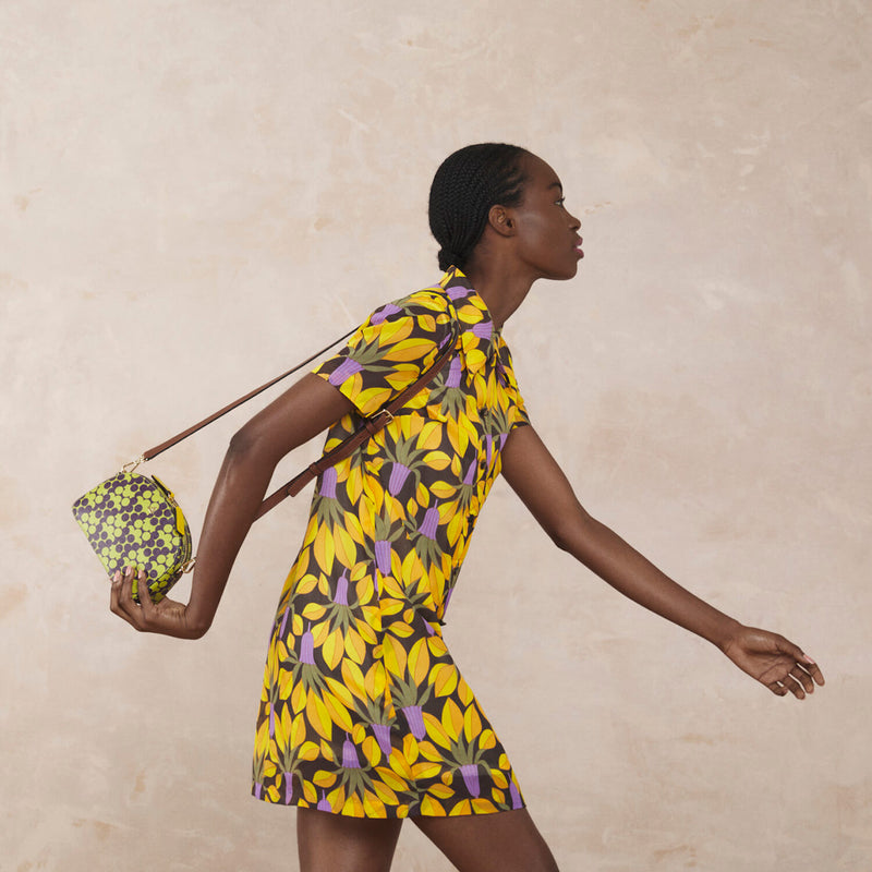 Model wearing the Babaluna Crossbody Handbag in Purple Puzzle Flower pattern by Orla Kiely