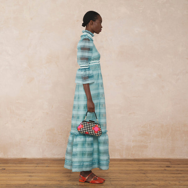 Model wearing the Jenny D Clutch Bag in Fuchsia Flower Polka Dot pattern by Orla Kiely