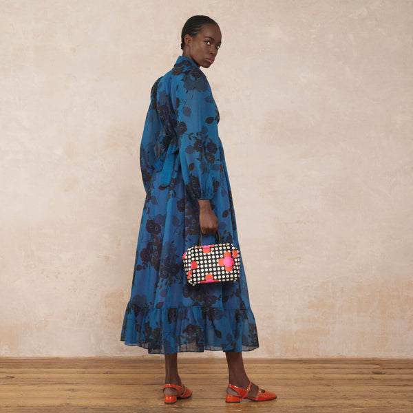 Model wearing the Concertina Crossbody Tote Bag in Fuchsia Flower Polka Dot pattern by Orla Kiely