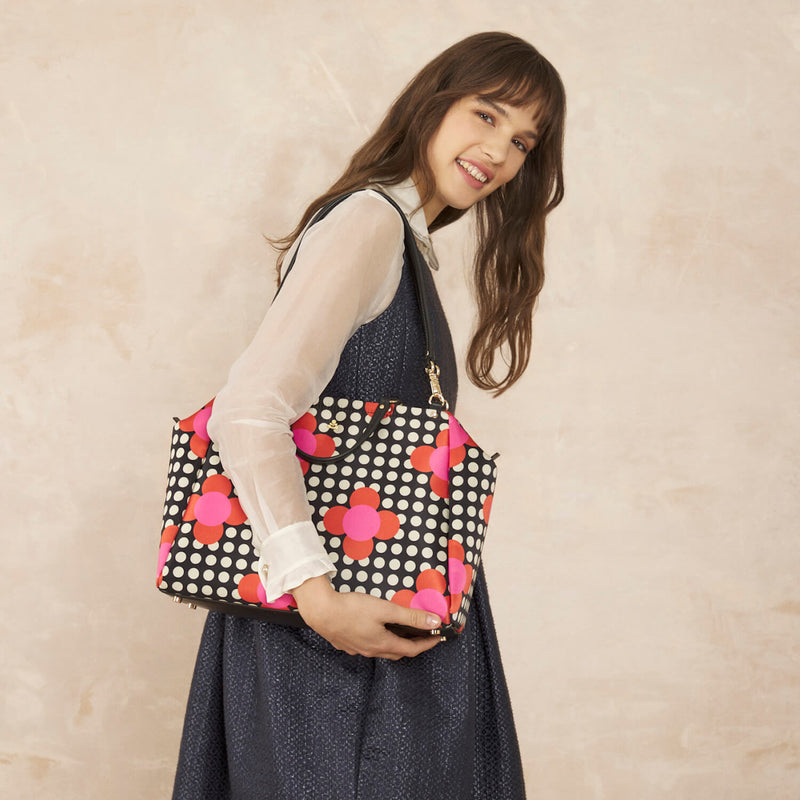 Model wearing the Opera Big Tote Bag in Fuchsia Flower Polka Dot pattern by Orla Kiely