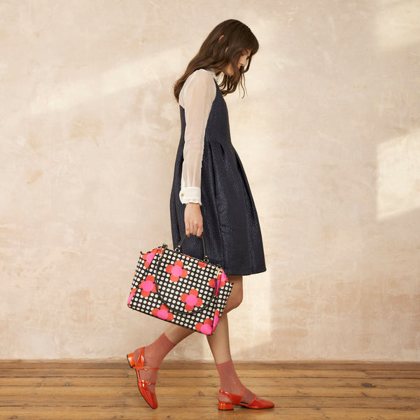 Model wearing the Opera Big Tote Bag in Fuchsia Flower Polka Dot pattern by Orla Kiely