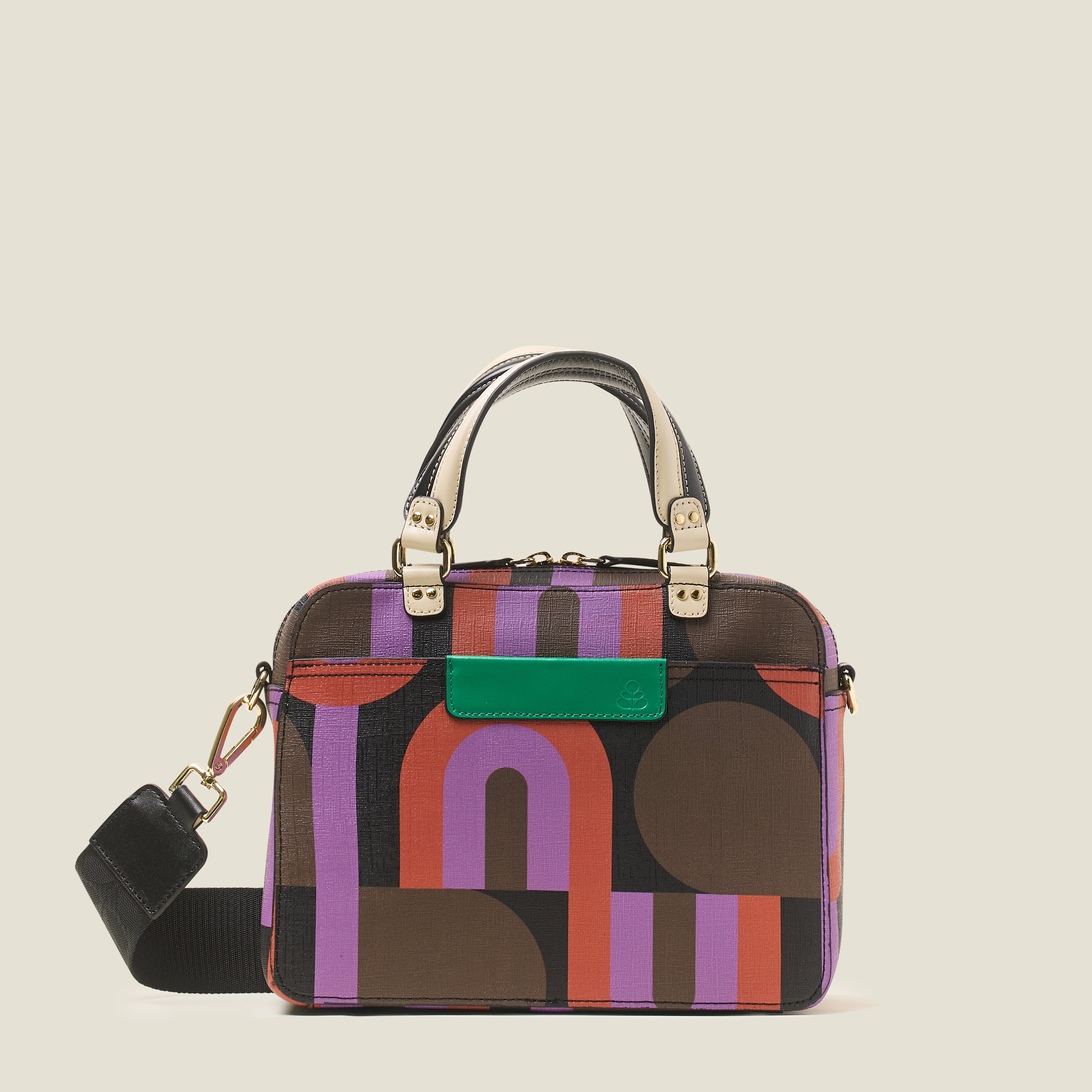 Front view of square shaped handbag in a retro purple, red and brown print, featuring grab handles, crossbody strap and zip closure.