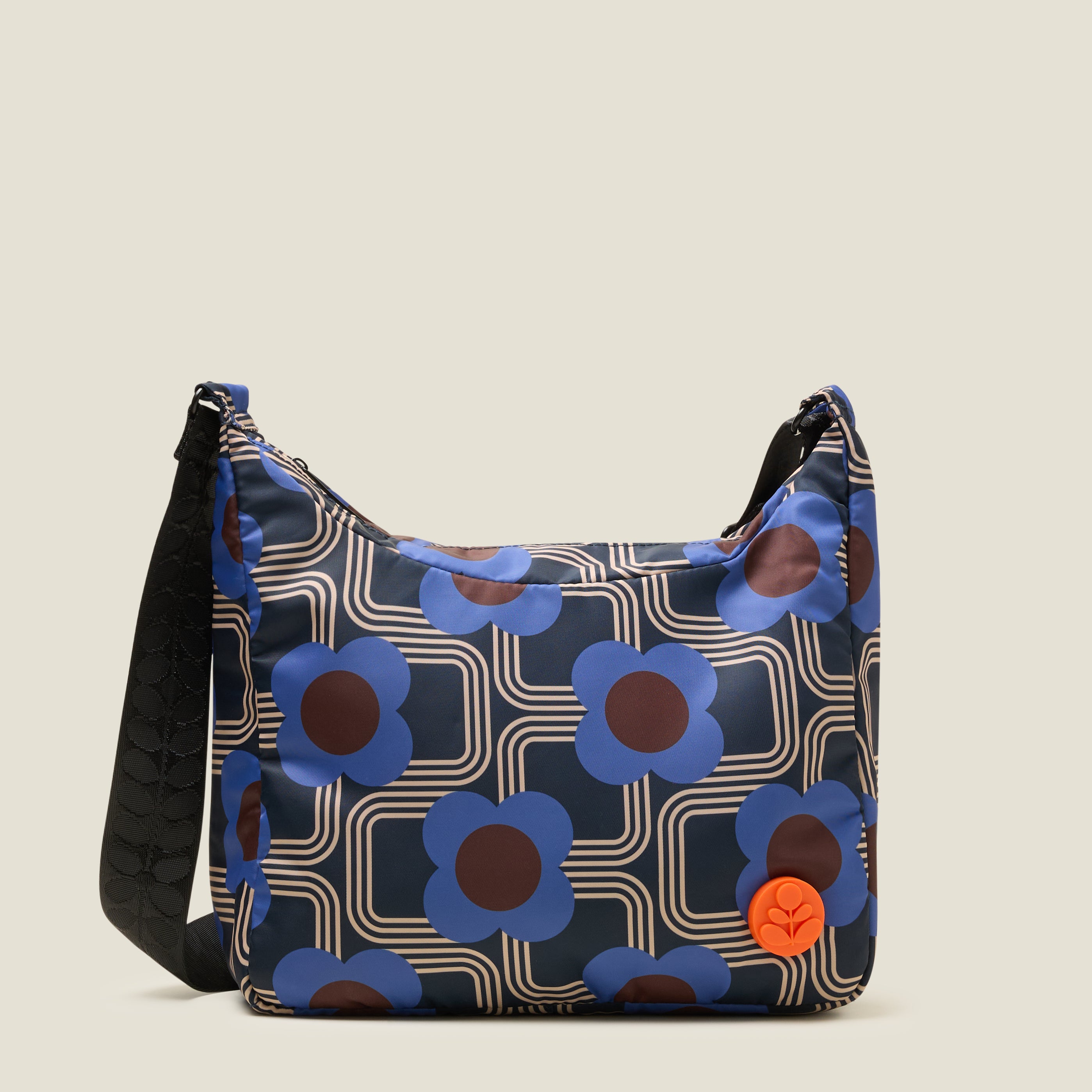 Front view of crossbody bag in an electric blue floral pattern. The handbag features a orange stem logo detail.