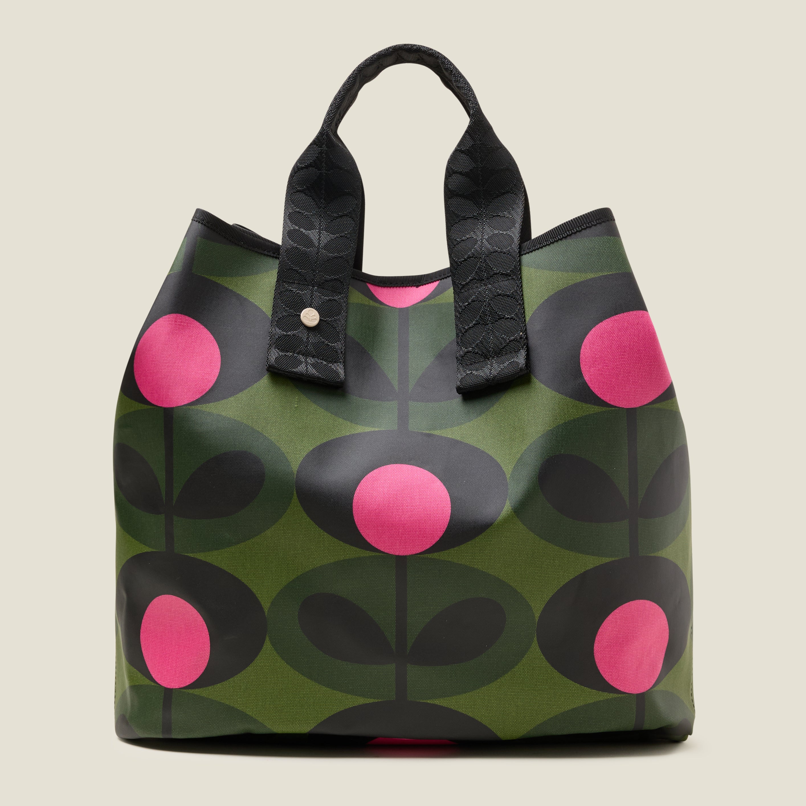 Women's large green tote bag with pink and black floral pattern with with top corners folded in for more security, with two short grab handles.