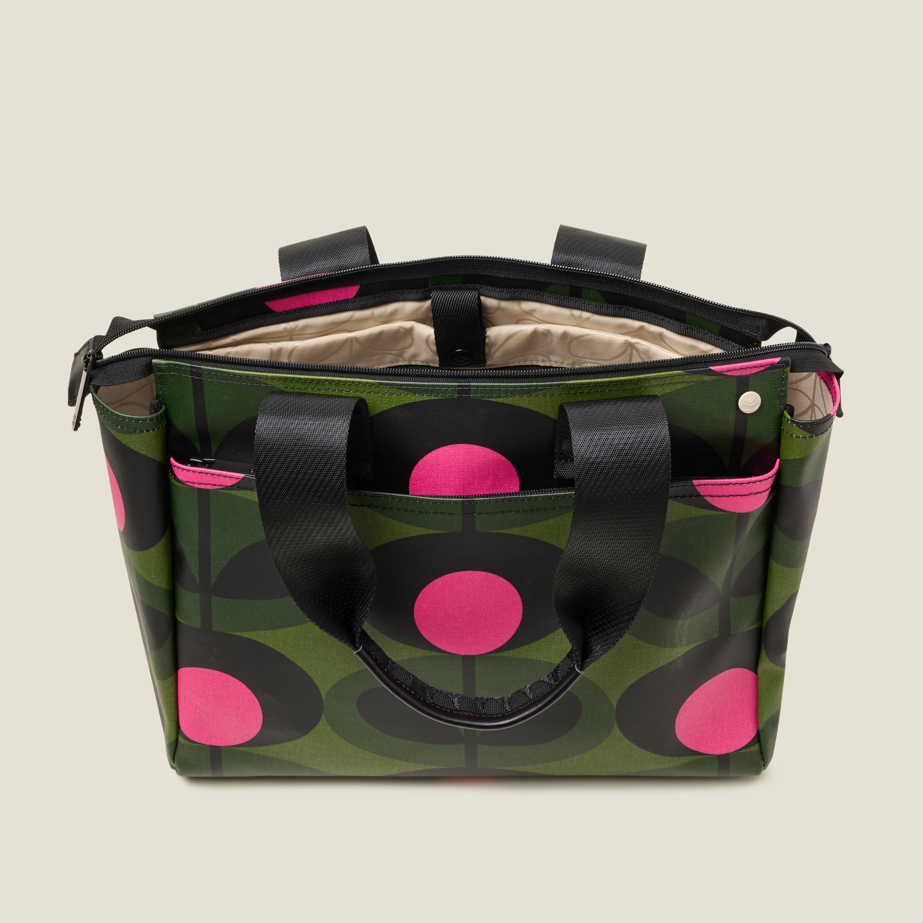 Inside view of a tote bag with a green and pink stem pattern, featuring a padded laptop sleeve.