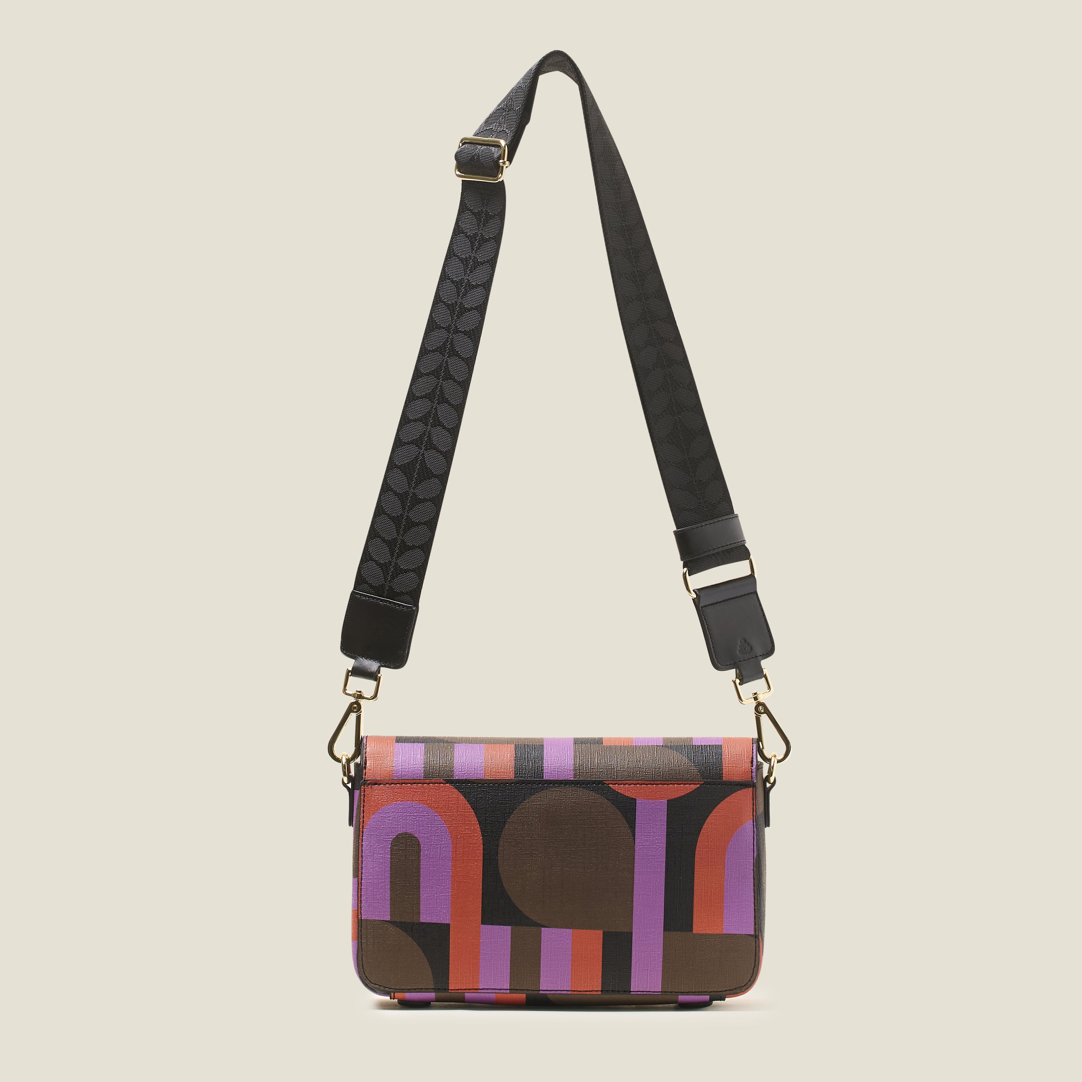 Back view of a patterned handbag with a black crossbody detachable strap.