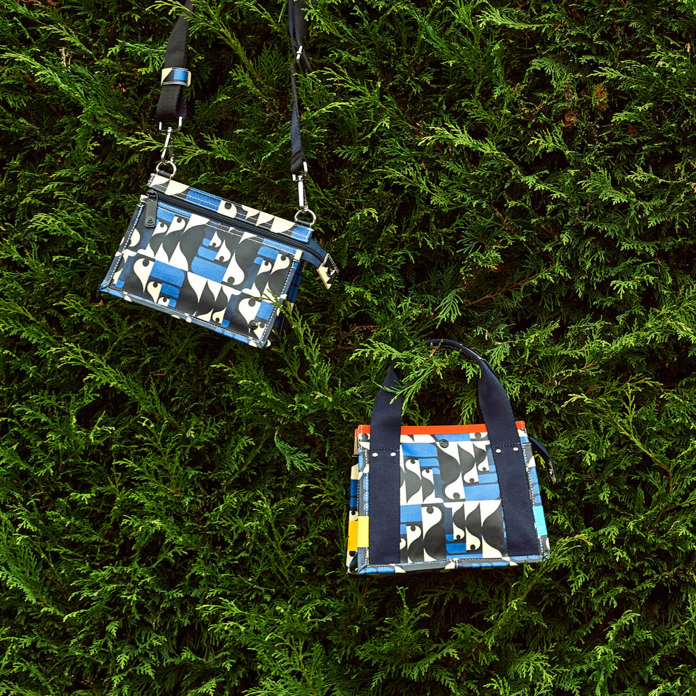 Two toucan Orla Kiely bags bags in a hedge