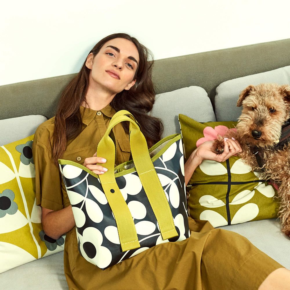 Person with a dog and a Carrysmall Orla Kiely bag 