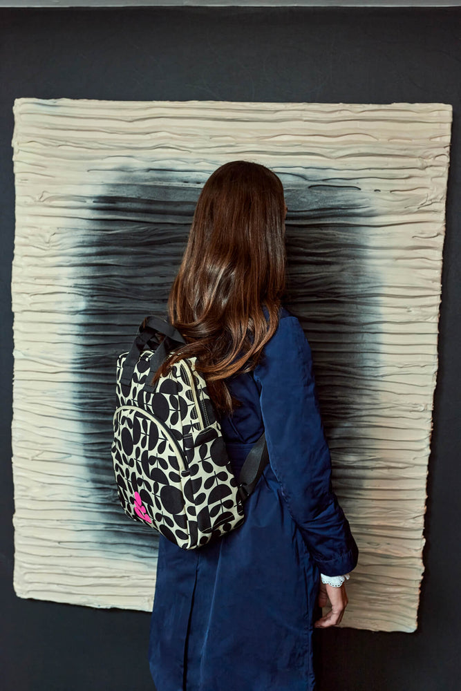 Standing in front of a piece of art with a bag for good Orla Kiely backpack