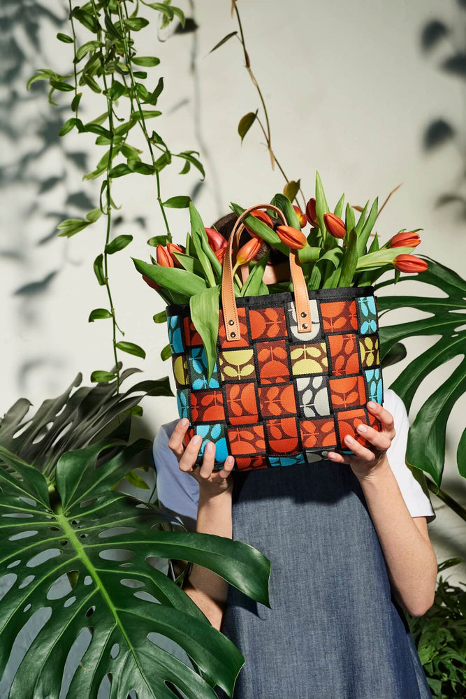 Tulips sticking out of a crochet Orla Kiely waste basket bag