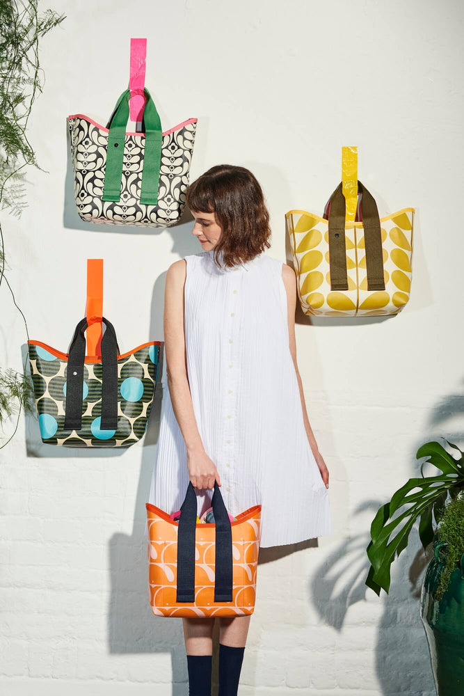 Orla Kiely totes stuck to the wall surrounding a woman in white