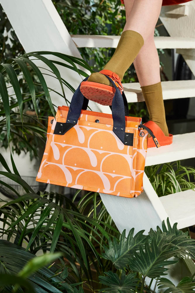 Balancing a beluga Orla Kiely landor bag on their foot