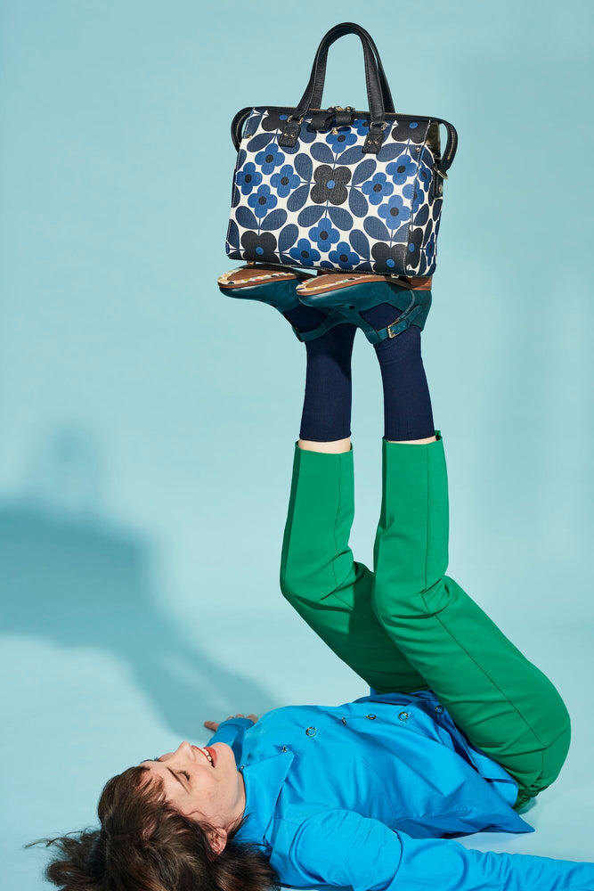 Person balancing an Orla Kiely messenger bag on her feet