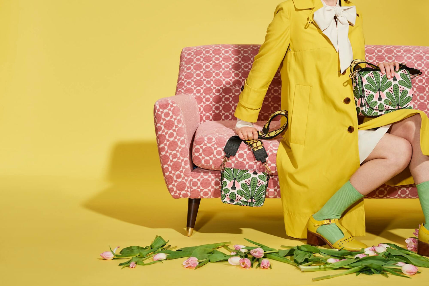 Sitting on sofa with busy bee Orla Kiely bags with flowers on the floor