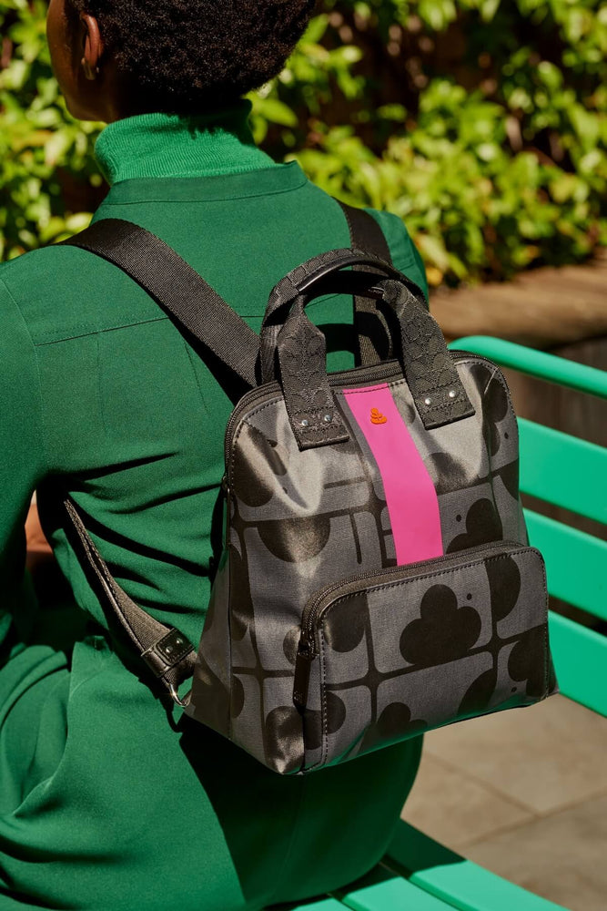 Facing away in a green coat with a black buddy backpack