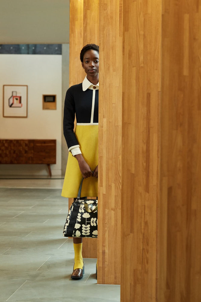 Holding an Orla Kiely sharpie bag in a wooden hallway