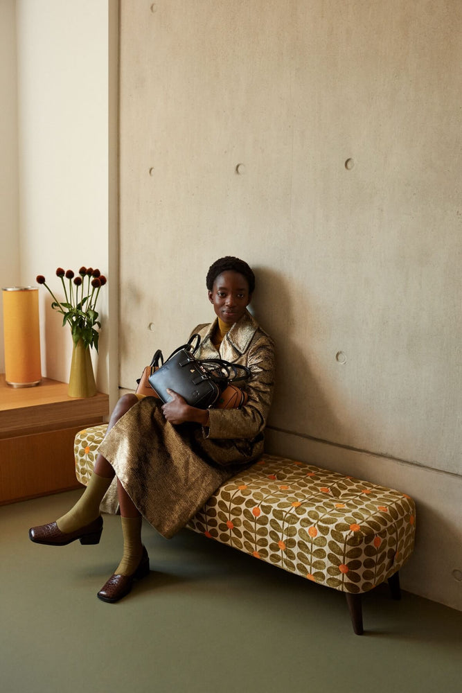 Sitting on an Orla Kiely banquette with a black leather bag