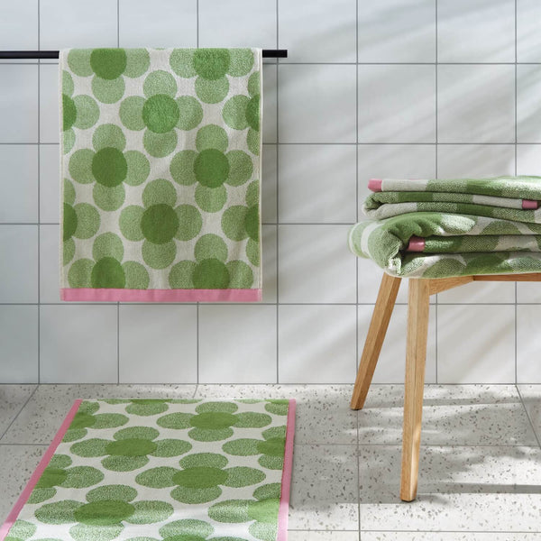 Lifestyle shot of the entire Orla Kiely retro flower clover green towel range