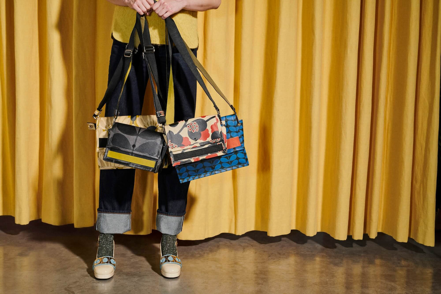 Orla Kiely bags dangled in front of denim jeans