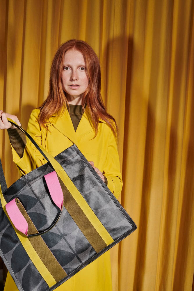 Model in yellow coat with Orla Kiely tote bag 