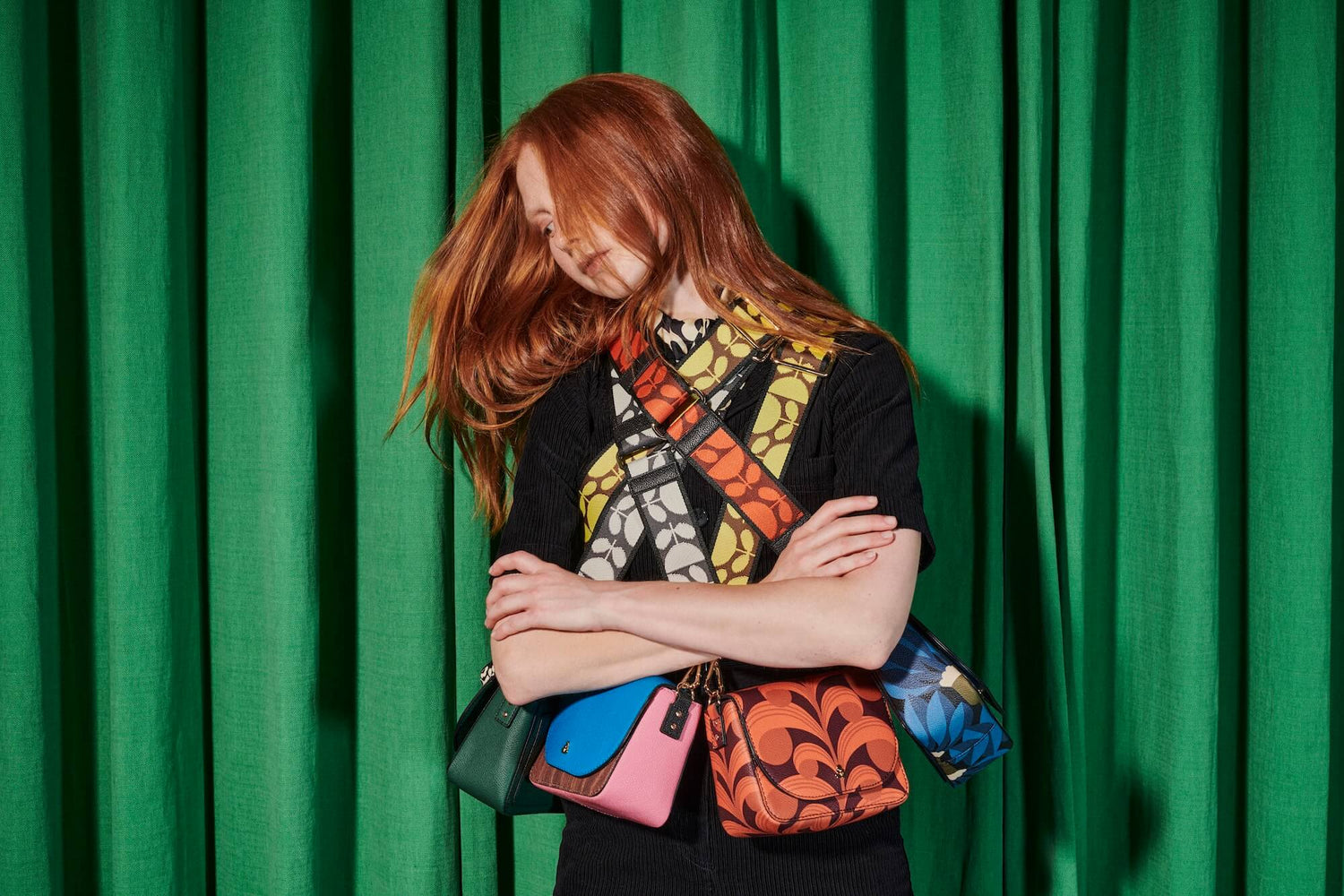 Model with four Orla Kiely crossbody bags on