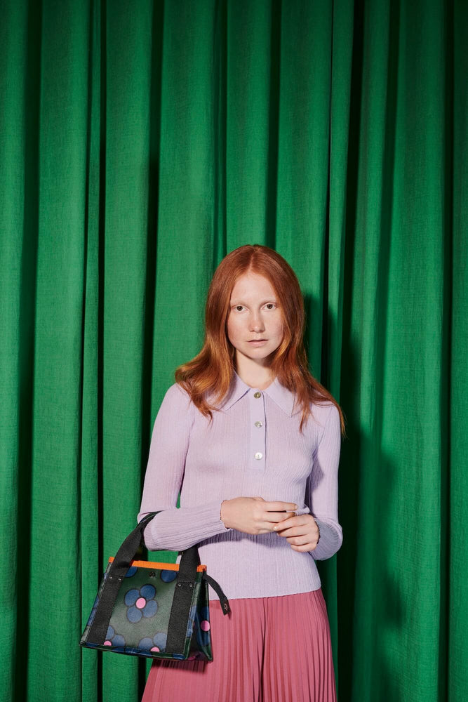 Red haired women in front of green with an Orla Kiely flat four bag 