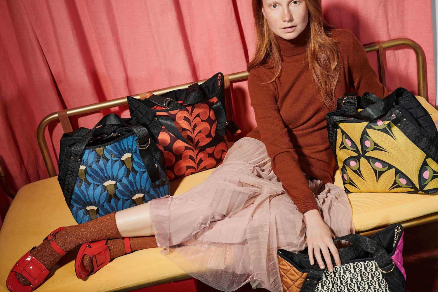 Woman on sofa surrounded by Orla Kiely gondola bags