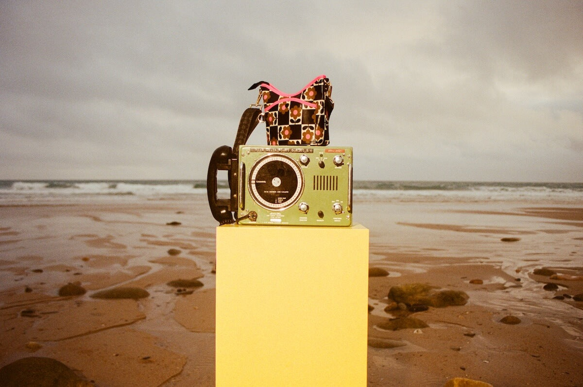 Orla Kiely cross carry bag on a radio by the beach 